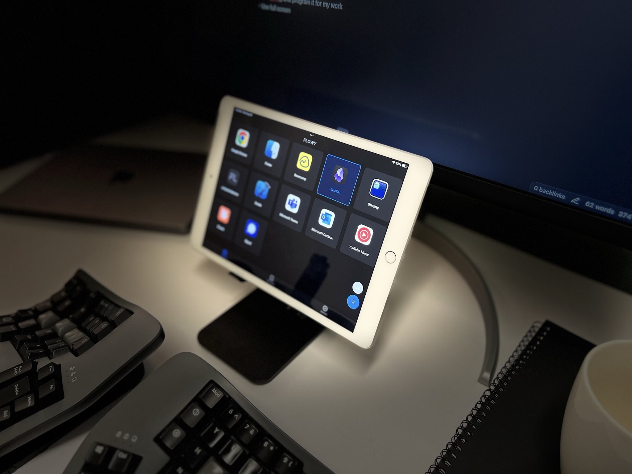 An iPad running Flowy.keypad next to a Mac on a desk